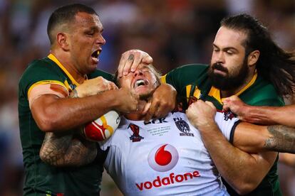 Ashton Sims de Fiji es placado por Will Chambers (i) y Aaron Woods (d) de Australia durante la semifinal del campeonato del mundo de Rugby masculino en Brisbane. 