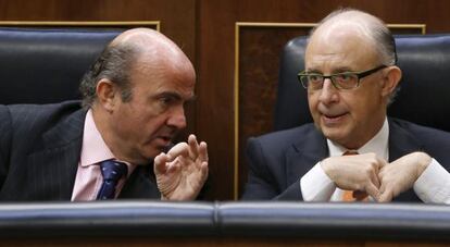 Luis de Guindos (izquierda) y Cristóbal Montoro, en el Congreso.