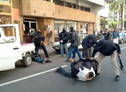 Policías de las fuerzas especiales marroquíes inmovilizan a dos sospechosos de estar relacionados con los terroristas suicidas.