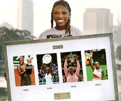 Serena Williams sostiene un cuadro con imágenes de sus triunfos en Roland Garros, Wimbledon, EE UU y Australia.