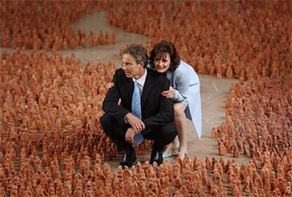 Tony Blair y su esposa, Cherie, posan en medio de una composición de un artista británico ayer en Pekín.