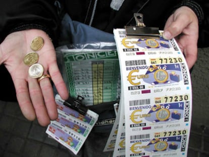 Un vendedor de la ONCE muestra unos cupones y unas monedas.