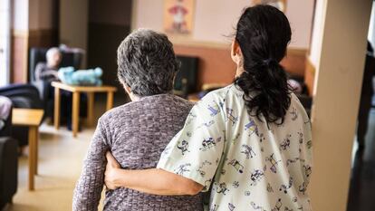 Una cuidadora ayuda a una mujer en una residencia de ancianos. 