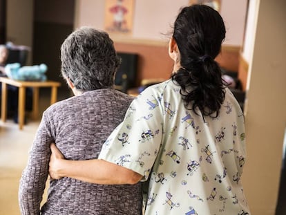 Una cuidadora ayuda a una mujer en una residencia de ancianos. 