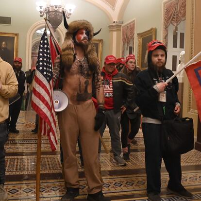 Supporters of US President Donald Trump, including member of the QAnon conspiracy group Jake Angeli, aka Yellowstone Wolf (C), enter the US Capitol on January 6, 2021, in Washington, DC. - Demonstrators breeched security and entered the Capitol as Congress debated the a 2020 presidential election Electoral Vote Certification. (Photo by Saul LOEB / AFP)