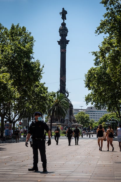 Un policía vigila la estatua de Colón en Barcelona.