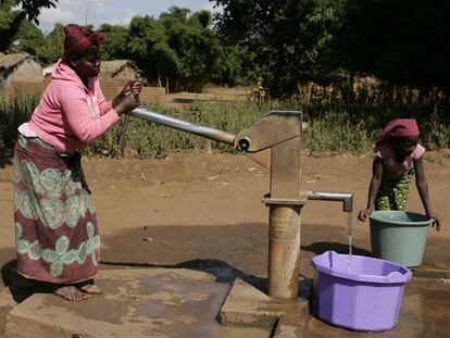 Una mujer y una niña extraen agua en Mzingo (Malaui).