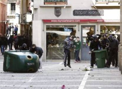 Grupos de jóvenes lanzan botellas de cristal contra efectivos de la Policia Nacional en la Calle San Miguel de Pamplona durante los incidentes ocurridos en el Casco Viejo con varios grupos de estudiantes tras la manifestación que ha recorrido las principales calles de la ciudad en la jornada de huelga convocada contra la LOMCE en todo el Estado.