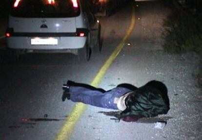 El cadáver de uno de los observadores internacionales asesinados cerca de Hebron, tendido en la carretera.