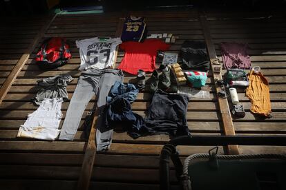 Los objetos encontrados dentro de la mochila rescatada. Entre ellos había blusas, pantalones, champús y dos láminas de dibujos de henna. 


