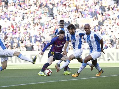 Messi, rodeado de rivales durante el derbi.