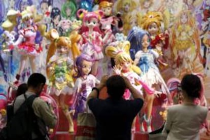 Visitantes fotografían las figuras de la serie animada japonesa Pretty Cure for the PreCure All Stars expuestas en el stand de Bandai Co. durante la inauguración ayer de la Feria del Juguete de Tokio.