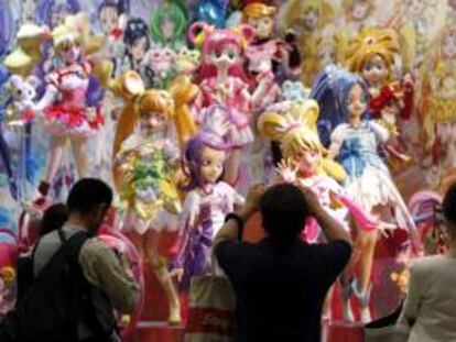 Visitantes fotografían las figuras de la serie animada japonesa Pretty Cure for the PreCure All Stars expuestas en el stand de Bandai Co. durante la inauguración ayer de la Feria del Juguete de Tokio.