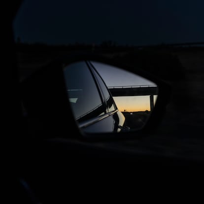 Las últimas luces del día se reflejan en el retrovisor al paso del coche por el límite entre Badajoz y Sevilla. 