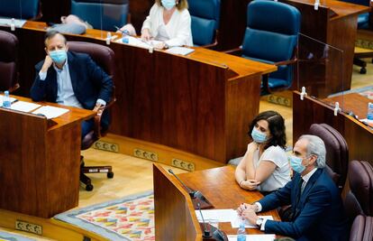 Alberto Reyero observa a Isabel Díaz Ayuso y Enrique Ruiz-Escudero, durante un pleno de la Asamblea.
