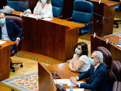 Alberto Reyero observa a Isabel Díaz Ayuso y Enrique Ruiz-Escudero, en el pleno de la Asamblea.