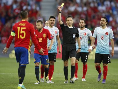 El arbitro Milorad Mazic (c) muestra tarjeta amarilla a Sergio Ramos.