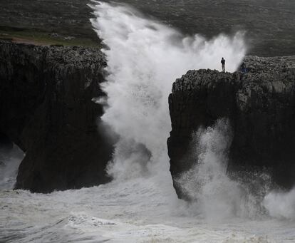 Un hombre hace una foto en Llames. Asturias mantiene la alerta naranja al esperarse olas de entre 5 y 6 metros de altura.