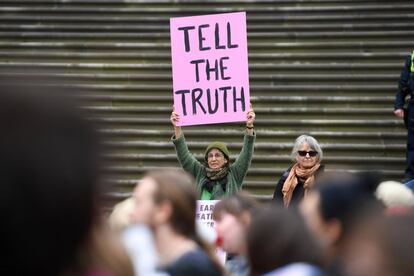 Una activista del colectivo Extinction Rebelion sujeta un cartel en el que se lee: 'Decid la verdad' en el exterior del Parlamento Estatal de Victoria, en Melbourne.