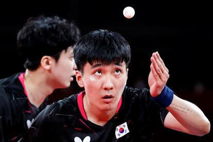 Lee Sangsu (derecha) y Jeoung Youngsik de Corea del Sur en acción durante el partido por la medalla de bronce de tenis de mesa contra Koki Niwa y Jun Mizutani de Japón.