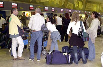 Un grupo de pasajeros espera en los mostradores de la compañía española Iberia en Barajas.