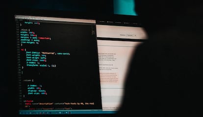 Un usuario introduce códigos en un ordenador.