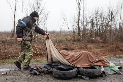 Un miembro de la fuerza de Protección Civil Ucrania observa a cuatro civiles muertos debajo de una manta en una carretera en Bucha, a 20 kilómetros de la capital, el sábado. Las ejecuciones sumarias documentadas en base a entrevistas con testigos se produjeron el 4 de marzo en esta localidad, al noroeste de la capital, y el 27 de febrero en Starii Bikiv, en la región de Chernihiv.