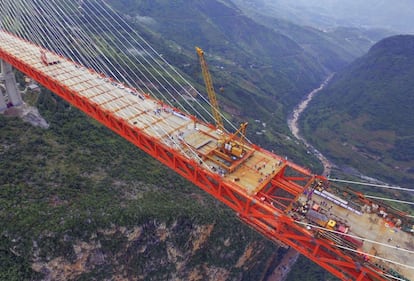 Trabajadores en la parte central del puente más alto del mundo, en la provincia china de Guizhou.