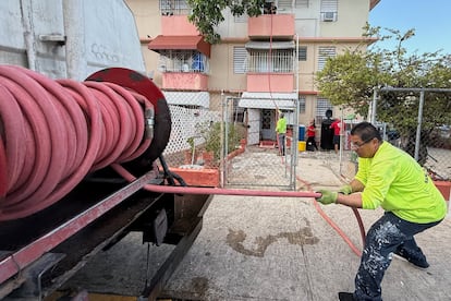 Un hombre reparte agua no potable gratuita a los residentes del complejo de vivienda Villa Kennedy en San Juan.Danica Coto (AP).