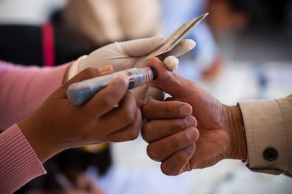 Una funcionaria coloca tinta indeleble en el dedo de un votante en una casilla en el municipio de Santiago Tianguistenco, en el Estado de México.