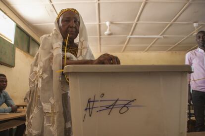 Una mujer vota en la escuela Banifandou II de Niamey ante la atenta mirada de los delegados.