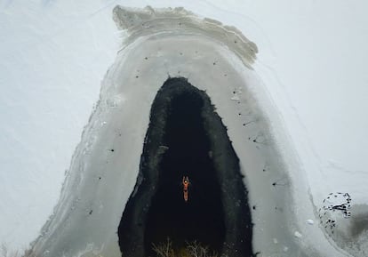 Un hombre nada tras romperse el hielo de un lago congelado en un parque de Shenyang (China).