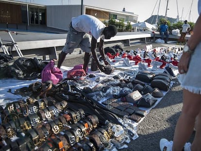 Un mantero vende sus productos en el muelle de la Barceloneta.