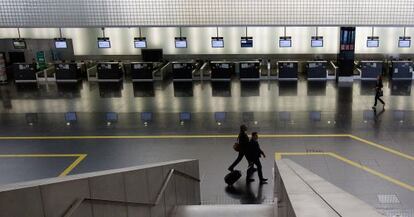 Unos pasajeros caminan por uno de los módulos de la Terminal 2 del aeropuerto de El Prat, ayer.