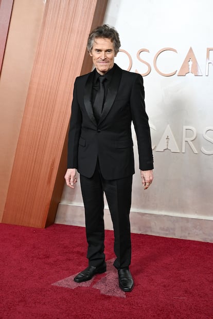 Willem Dafoe ('Nosferatu'), de negro de la corbata a los zapatos con un 'look' de Prada.