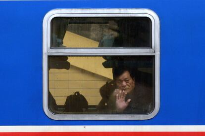 Un hombre mira a través de la ventana de un tren en una estación de ferrocarril en Beijing. La migración anual más grande del mundo comenzó el 16 de enero en China, con decenas de miles de personas que se dirigen a sus casas para con motivo de las celebraciones del Año Nuevo Lunar.