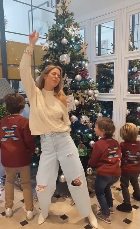 Amelia Bono y sus hijos bailando con el árbol de Navidad.