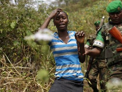 Un militar ruand&eacute;s escolta a una mujer en las afueras de Bangui.