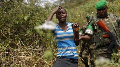 Un militar ruand&eacute;s escolta a una mujer en las afueras de Bangui.