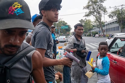 Migrantes de diferentes edades trabajan en un semáforo ubicado en la Avenida del Trabajo.