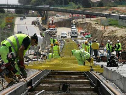 Varios obreros miden tramo a tramo la inclinación de los raíles del metro ligero el pasado lunes en Pozuelo.
