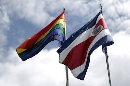 La bandera de arcoiris izada al lado de la bandera costarricense.