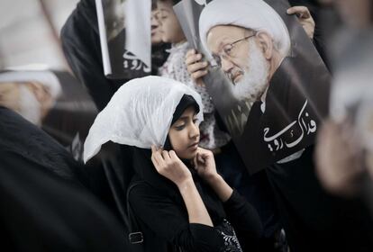 Mujeres de Bahrein sostienen fotos del principal clérigo chiíta, el jeque Isa Qassim, durante una manifestación contra el gobierno para apoyarle, en la aldea de Diraz, al oeste de la capital, Manama.