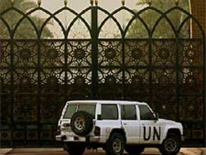 Un vehículo de la ONU permanece frente a un palacio de Sadam Husein.