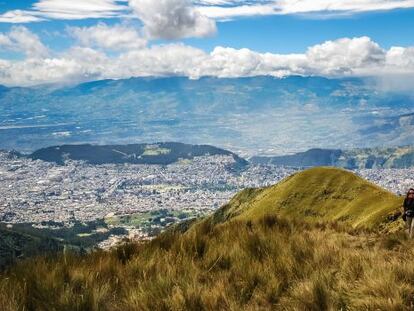Una senderista subiendo al Pichincha (4.784 metros), uno de los volcanes andinos que rodean la ciudad de Quito, al fondo. 