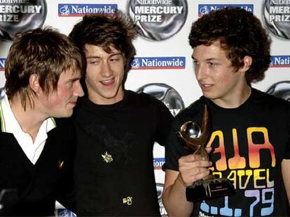 Jamie Cook, Alex Turner y Matt Helders posan con el galardón en las manos en Grosvenor House, en el centro de Londres.