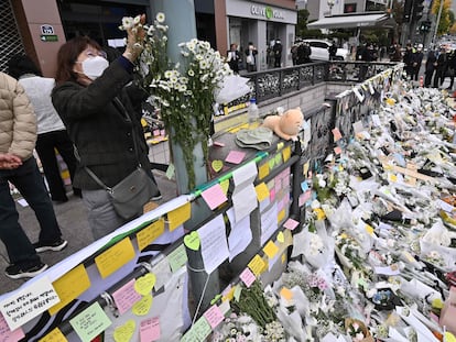 Una mujer colocaba flores el jueves en un altar improvisado a la salida del metro en el barrio de Itaewon, en Seúl.