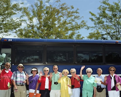 Un grupo de turistas ‘senior’ al lado de un autocar.  