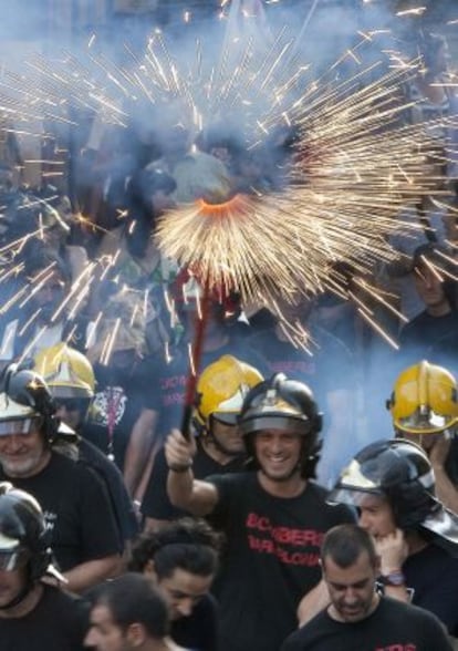 Un grupo de bomberos con fuegos artificiales, ayer en la Via Laietana de Barcelona