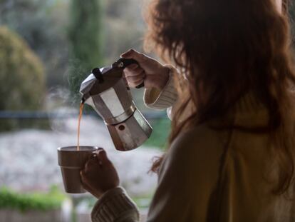 Una mujer se sirve una taza de café.